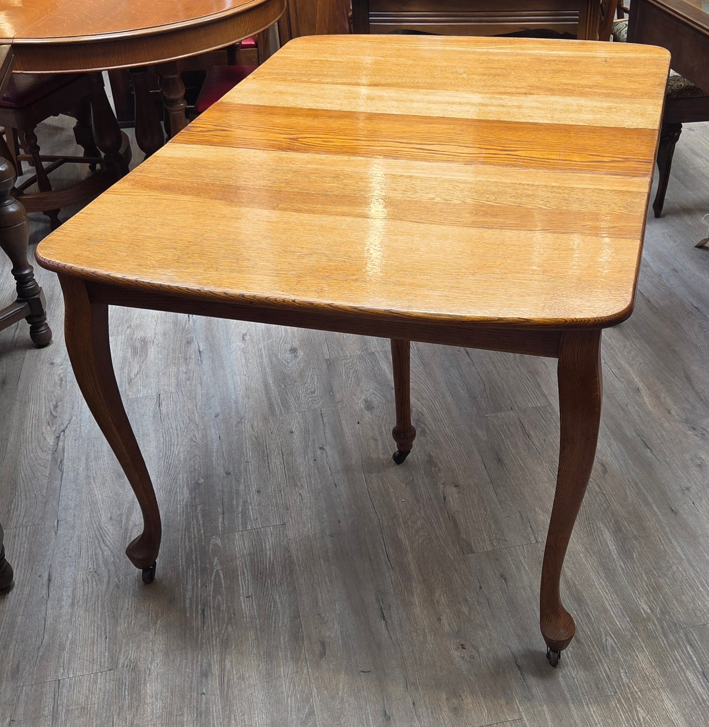 Golden oak dining table with 2 leaves, centre support legs