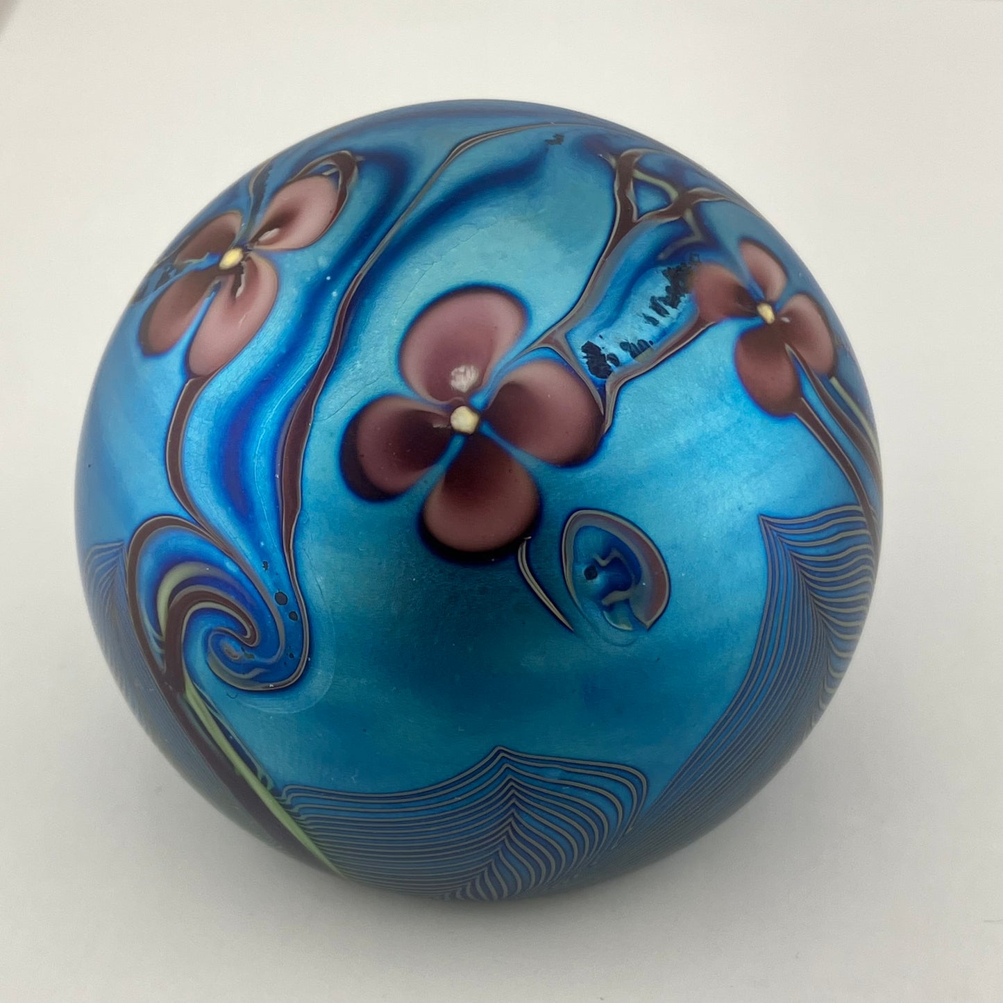 Orient and Flume Studio, Glass Paperweight, Round, Iridescent Dark Peacock Blues with Pink Flowers and Feathered Embellishment