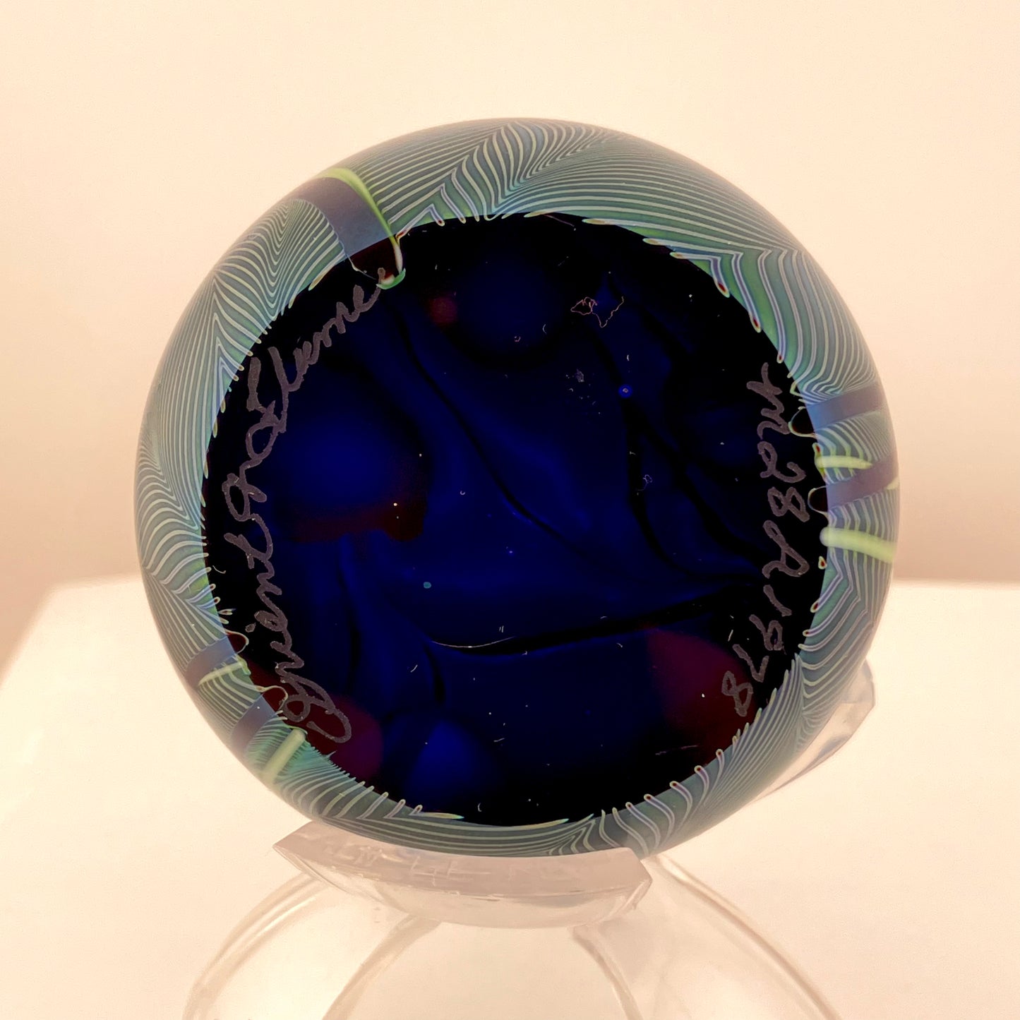 Orient and Flume Studio, Glass Paperweight, Round, Iridescent Dark Peacock Blues with Pink Flowers and Feathered Embellishment