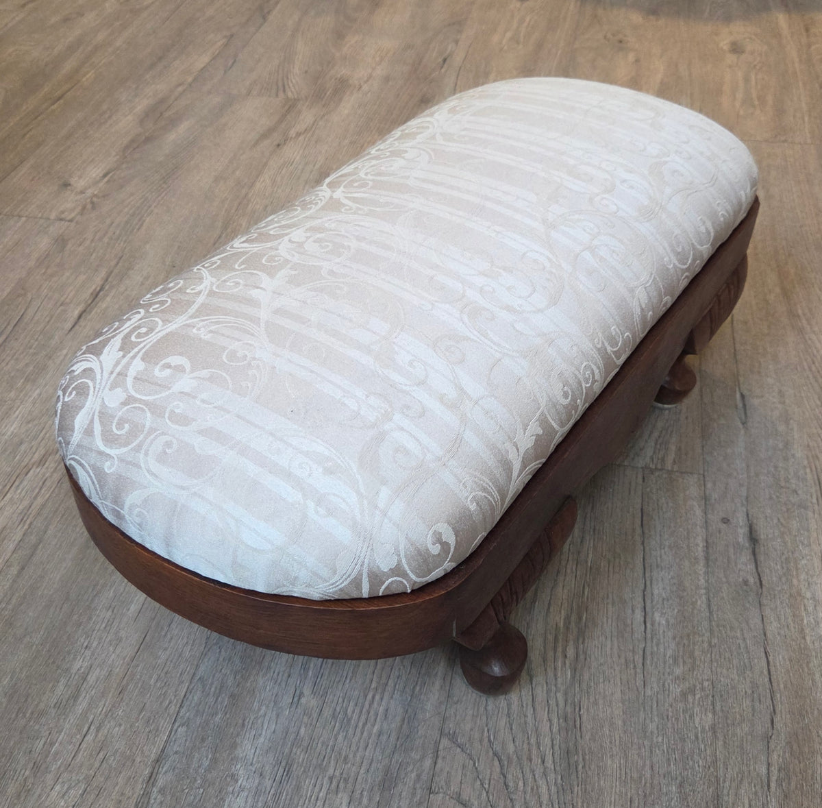 Oval antique mahogany footstool, cream coloured fabric