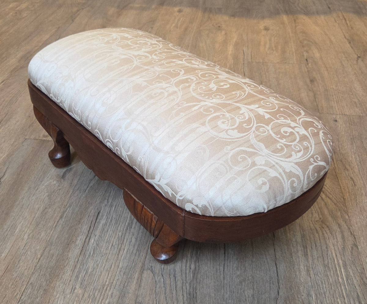 Oval antique mahogany footstool, cream coloured fabric