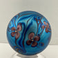 Orient and Flume Studio, Glass Paperweight, Round, Iridescent Dark Peacock Blues with Pink Flowers and Feathered Embellishment